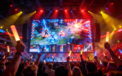 电竞赛事现场观众欢呼与巨大屏幕显示比赛画面